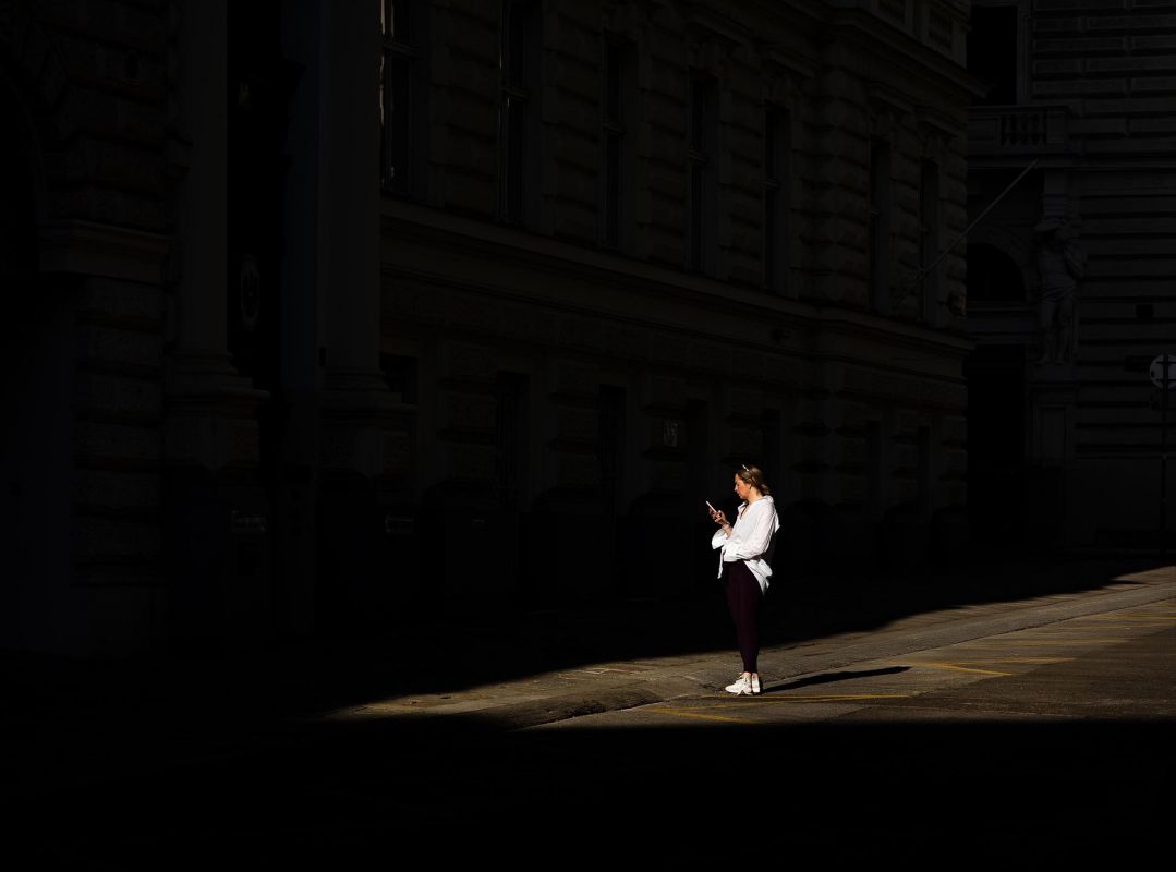 Licht und Schatten fotografiert in Wien und Menschen lassen nicht vom Mobiltelefon los
